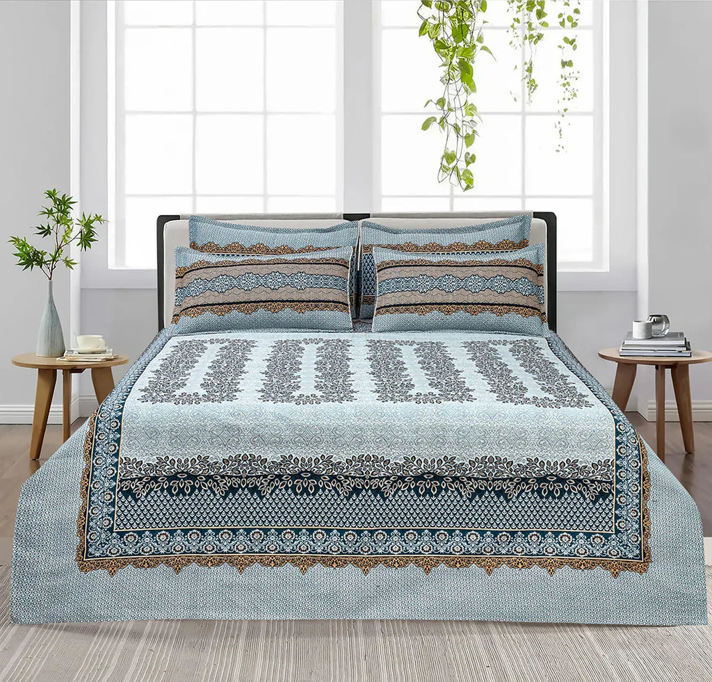Decorative bedspread with matching pillows on a bed in a bedroom setting.